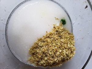 Close up view of a glass bowl with powders in it, to make Hop Spa products