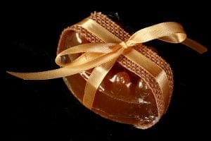 Close up view of a deep orange-yellow bar of soap, wrapped with ribbon