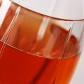 Close up photo of a tall wine glass with dark amber pumpkin mead in it.