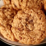 A close up view of a plate of spiced chewy oat raisin cookies.