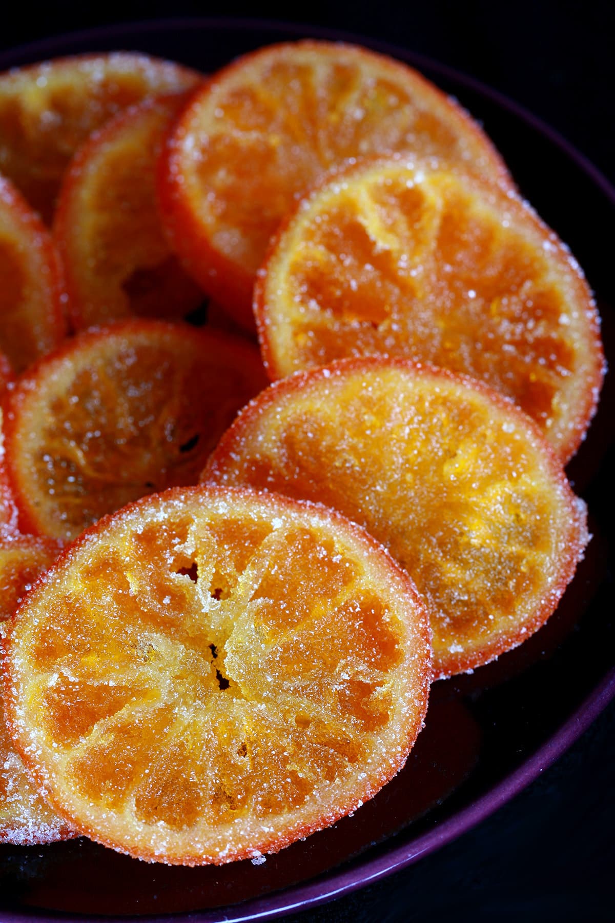 A blue plate with candied orange slices arranged on it.