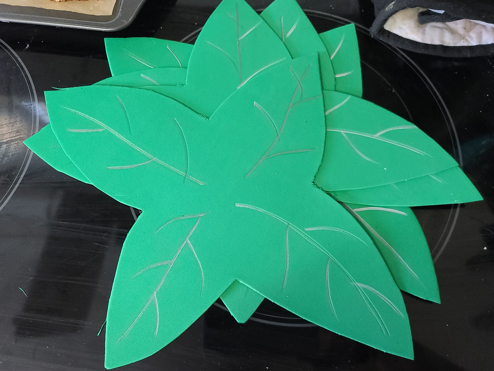 A stack of cut craft foam leaves, with silver accents drawn on.