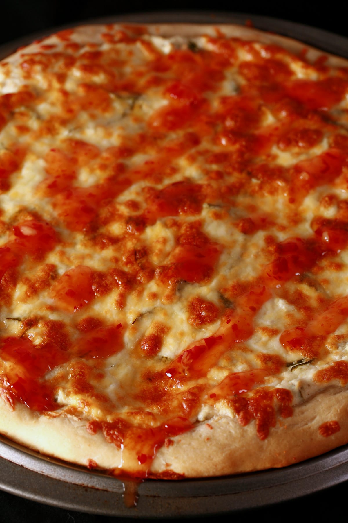 A close up view of a whole crab rangoon pizza, thick crust.
