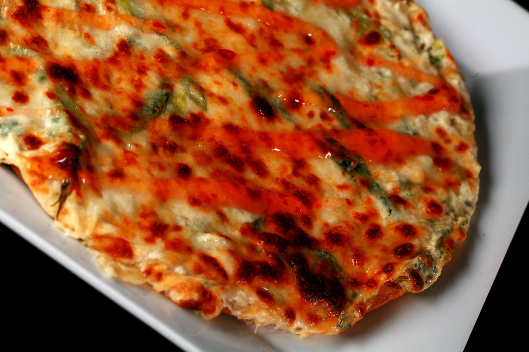A close up view of a thin crust crab rangoon pizza.