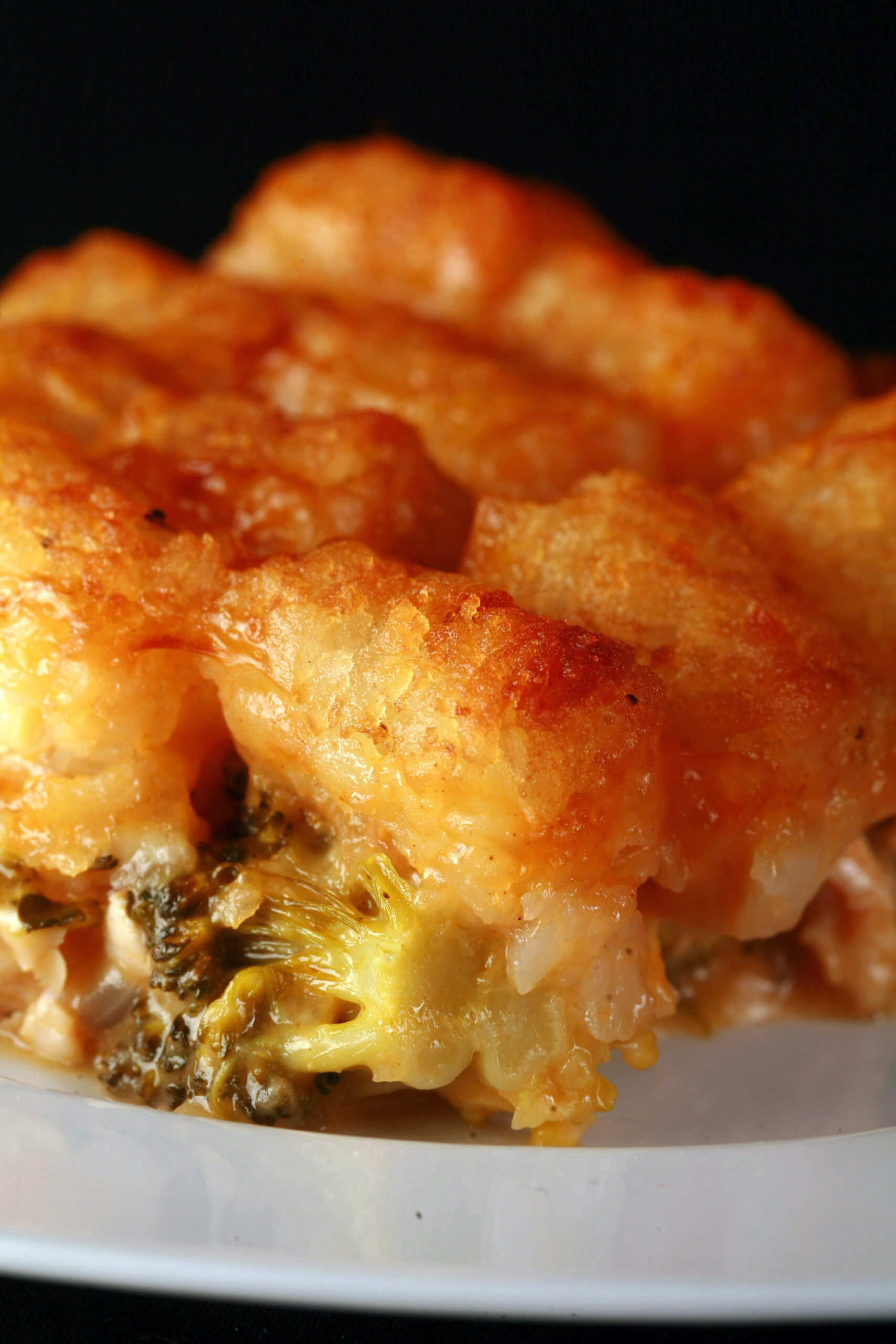 A plate of cheesy chicken and broccoli tater tot casserole.