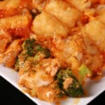 A plate of cheesy chicken and broccoli tater tot casserole.