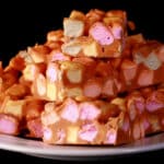 A small plate stacked high with butterscotch peanut butter confetti squares.