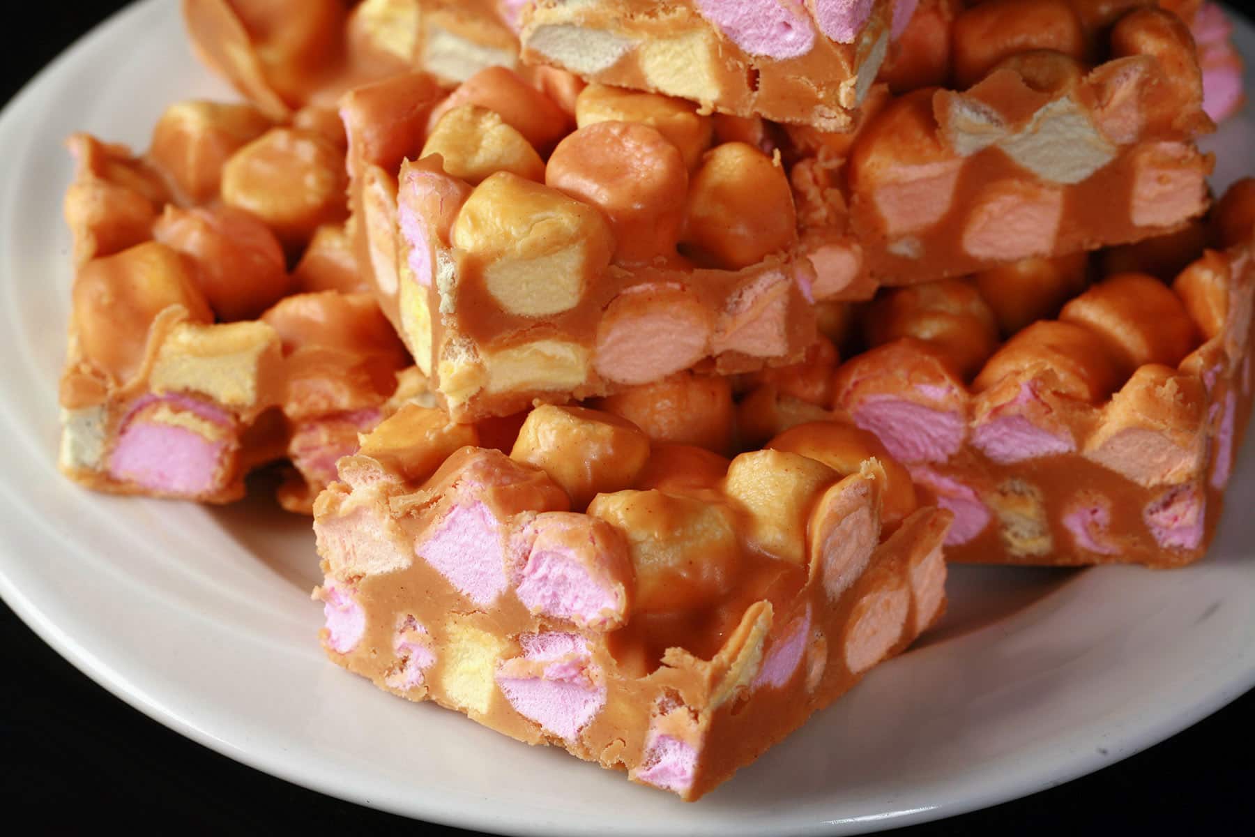 A small plate stacked high with butterscotch confetti squares.