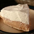 A slice of Earl Grey Pie - A greige custard pie, topped with whipped cream.