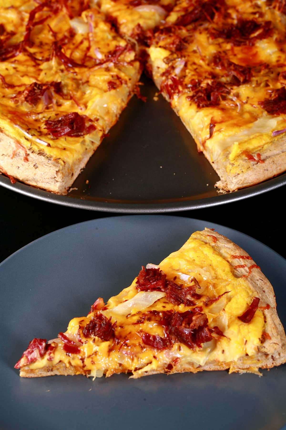 A slice of St Patrick’s Day Pizza on a plate in front of the rest of the pizza.