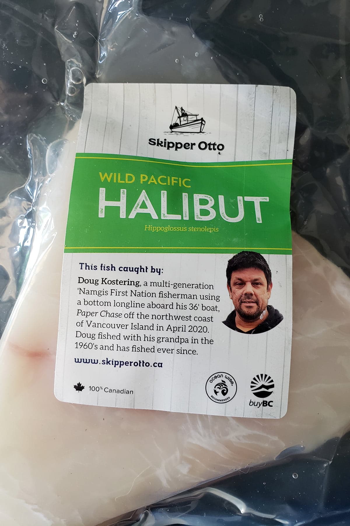 A shrink wrapped package of Skipper Otto halibut. A man's face and bio is pictured on the label.