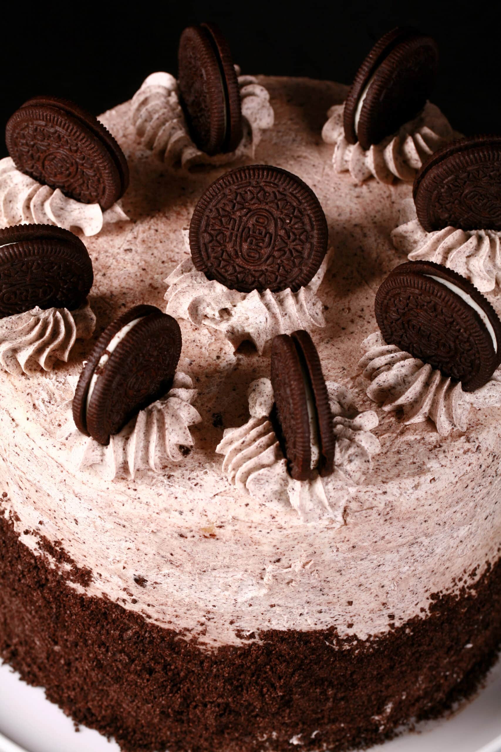 The top of a cookies n creme cake, decorated with cookies and cream frosting and whole Oreo cookies.