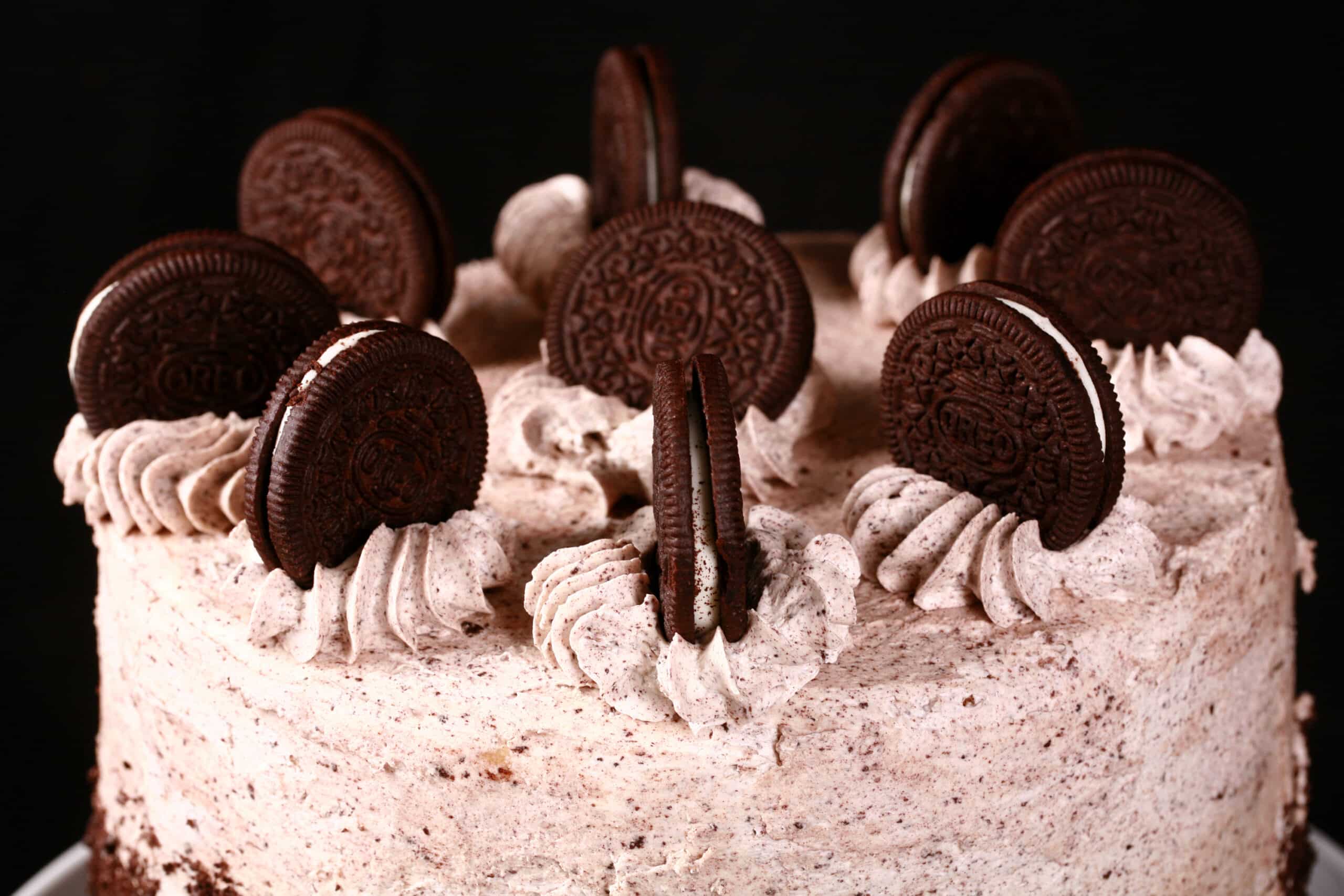 The top of a cookies n creme cake, decorated with cookies and cream frosting and whole Oreo cookies.