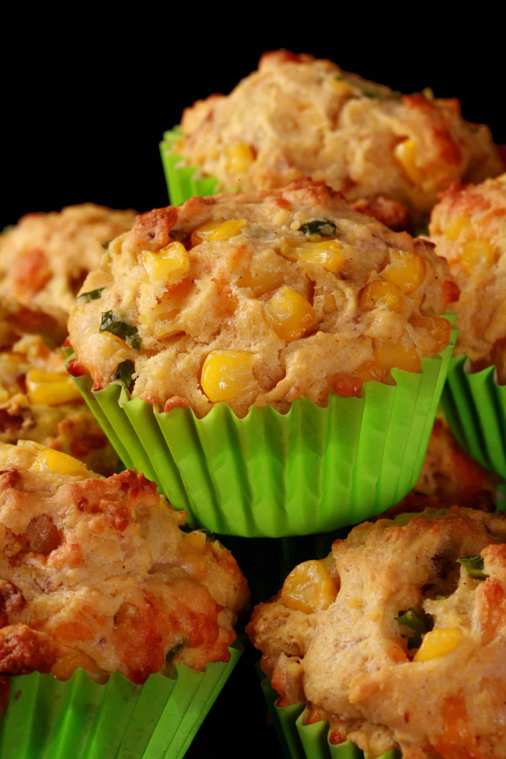 A plate of loaded breakfast corn muffins, with bacon, jalapeno, and corn kernels showing.