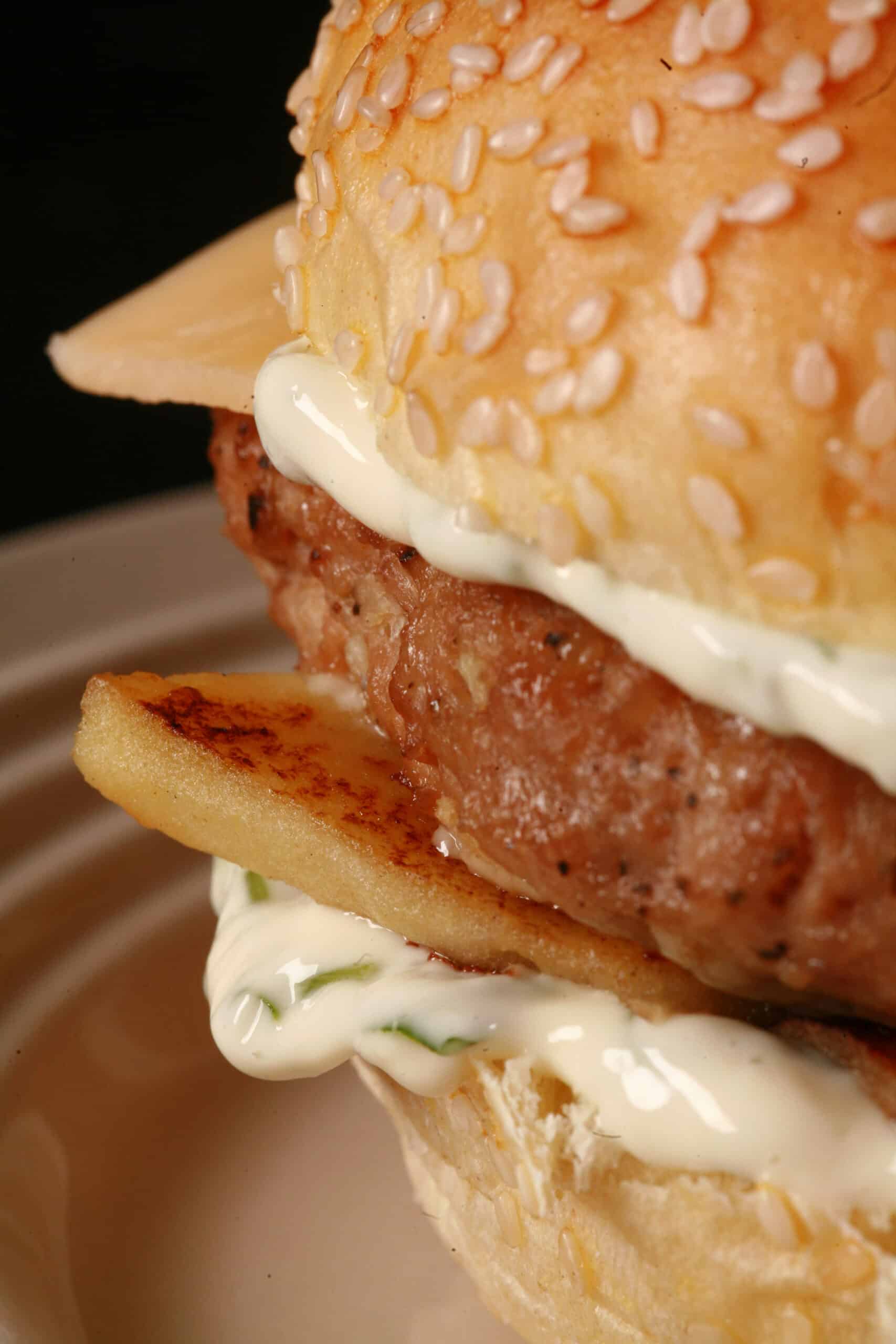 An apple chicken burger with basil mayonnaise and gouda cheese.