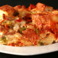 A square of deluxe pizza bread pudding: A brunch casserole featuring pepperoni, sausage, mushrooms, green peppers, black olives, marinara sauce, and cheese.