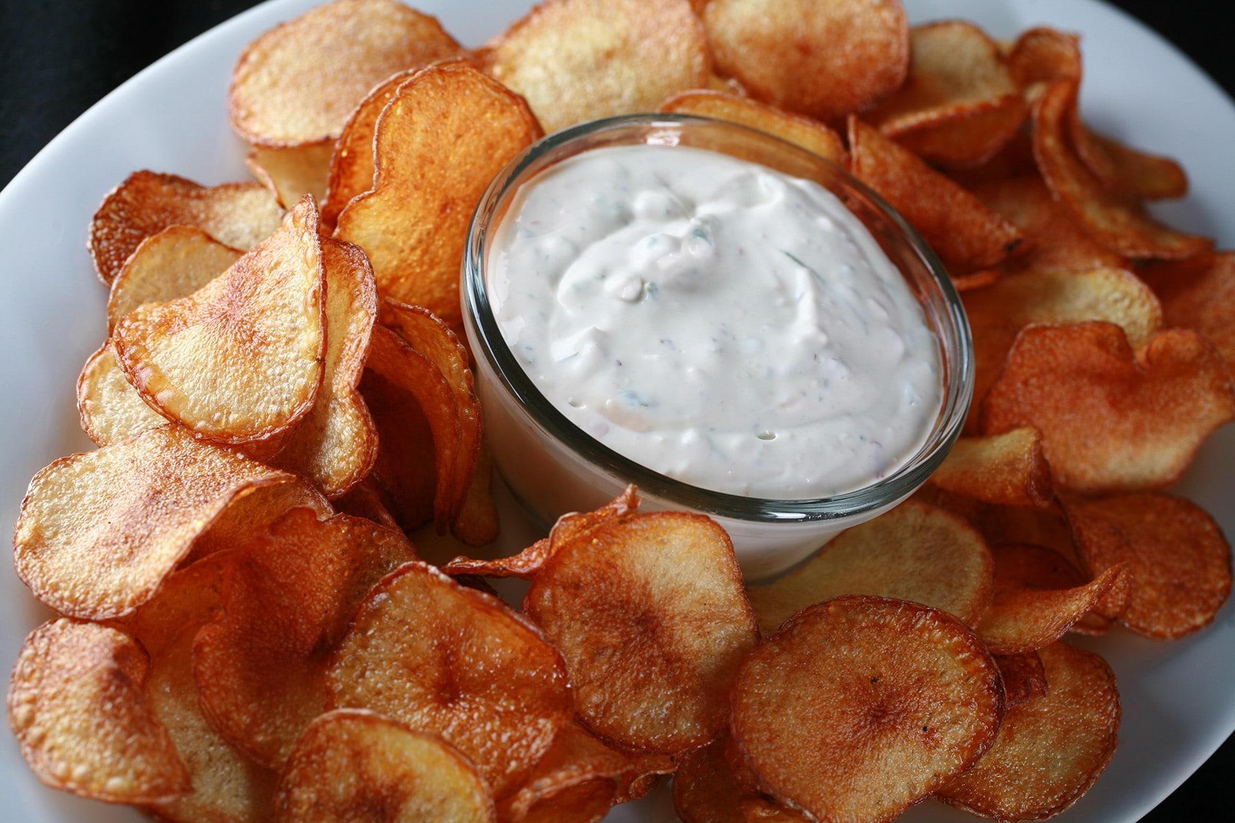 A large platter of cactus cut fries - spicy fried potato slices - with a bowl of cactus dip.