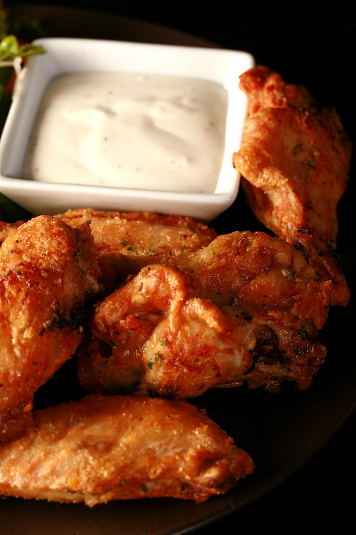 A close up view of a plate of tangerine-thyme dry rub seasoned wings.