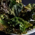 A bowl of curly green kale chips.
