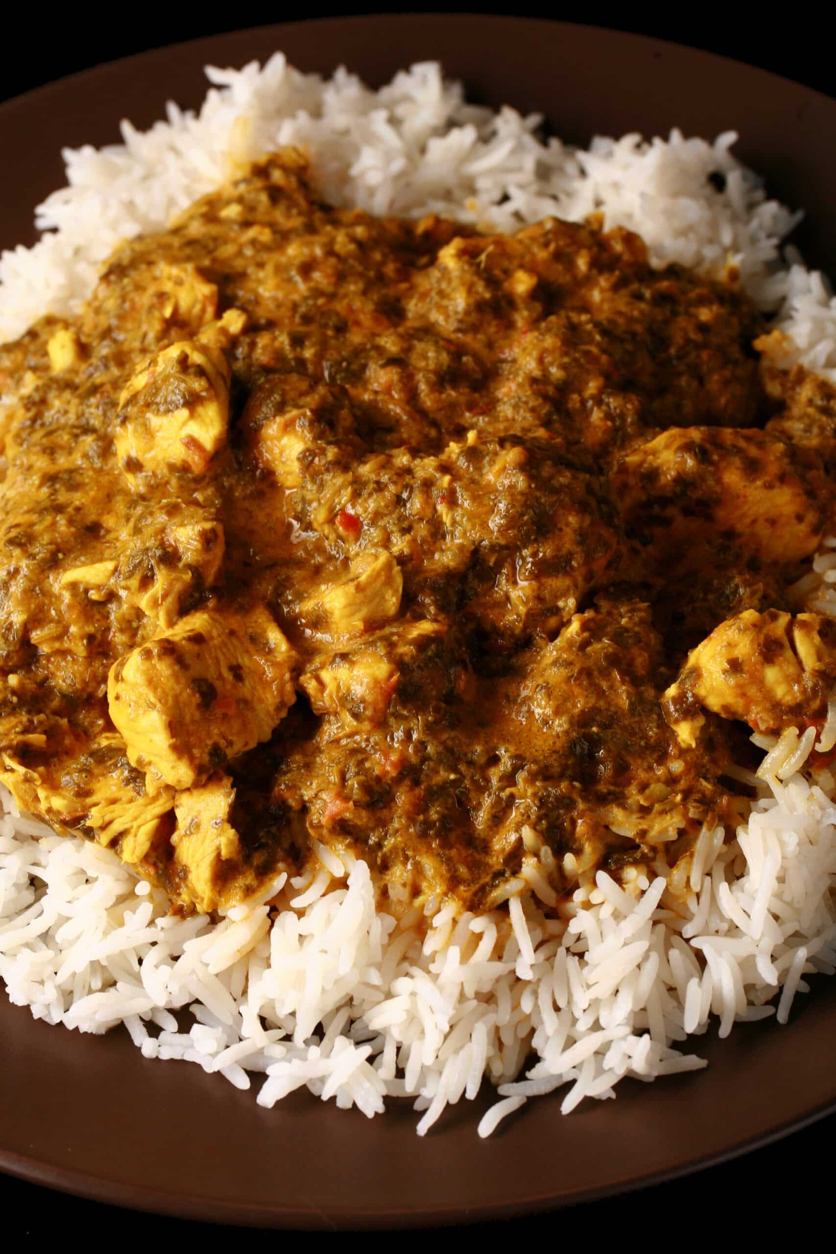 A plate of coriander chicken curry, served over basmati rice.