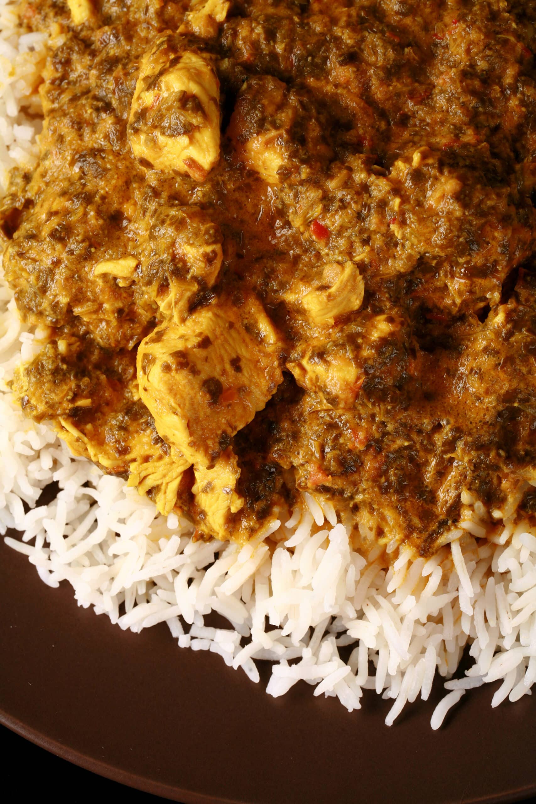 A plate of coriander chicken curry, served over basmati rice.