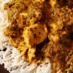 A plate of coriander chicken curry, served over basmati rice.