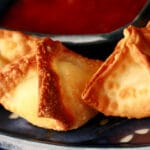 A small, blue, rectangular dish with pyramid shaped air fryer cream cheese wontons on it.