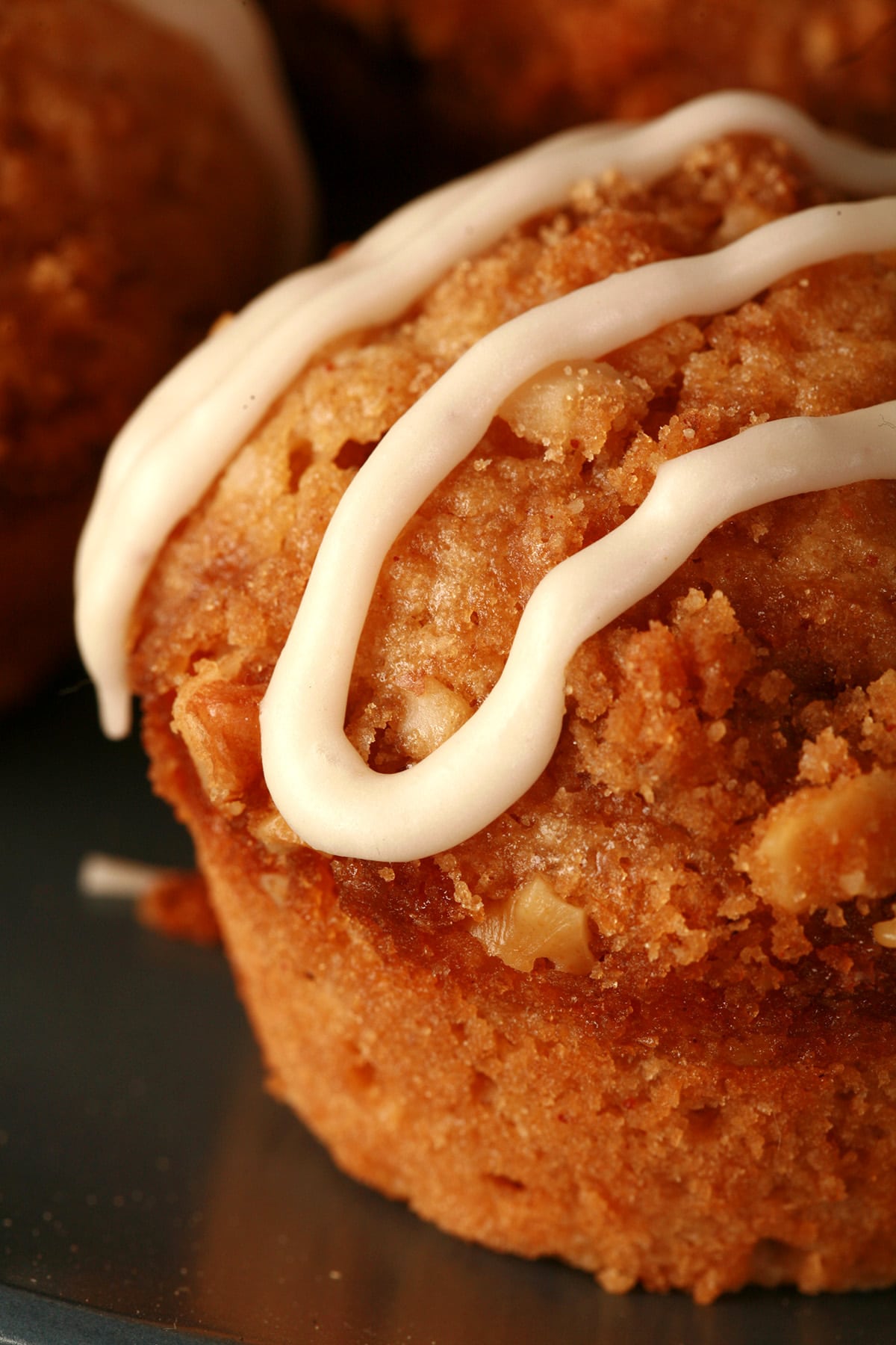 A plate of nutmeg coffee cake muffins, each drizzled with maple nutmeg glaze.