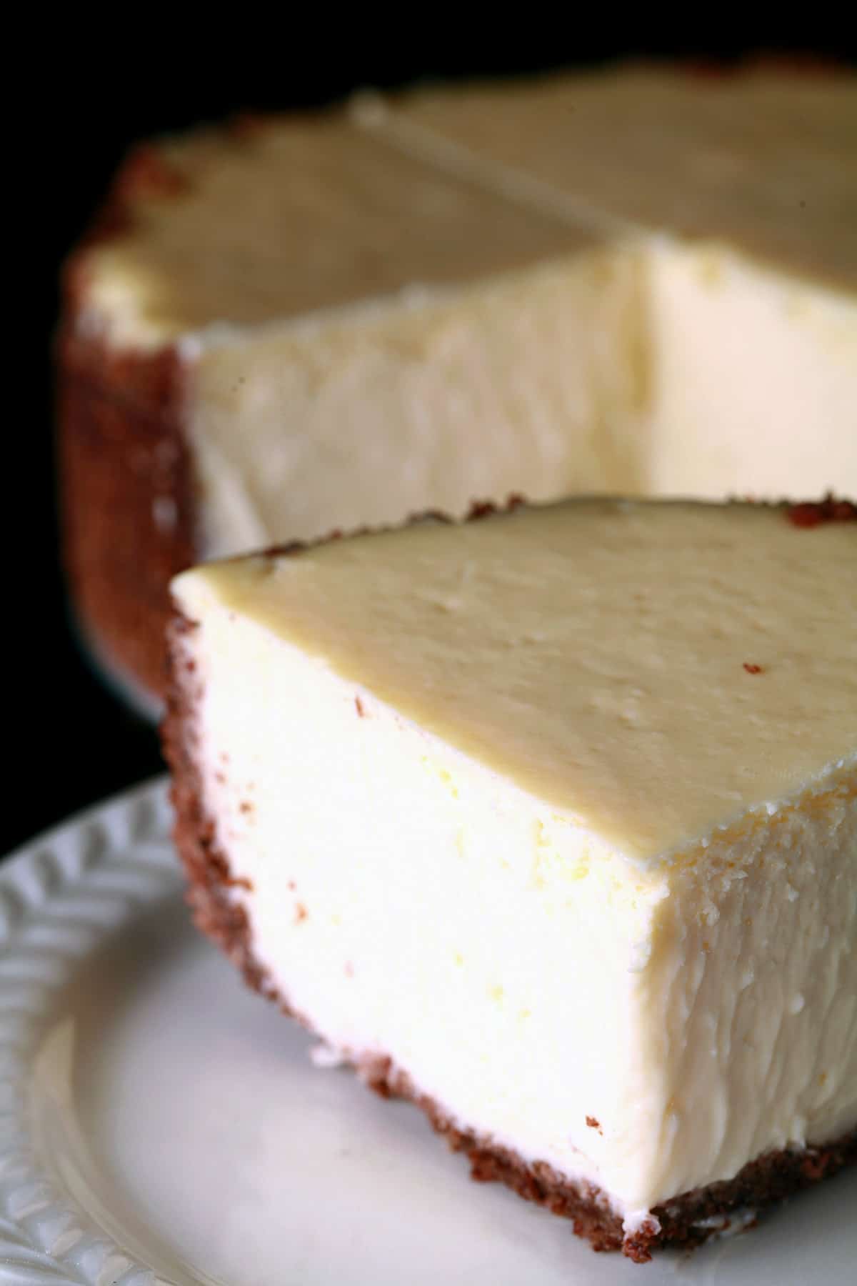 A close up view of a creamy 6 inch vanilla cheesecake.