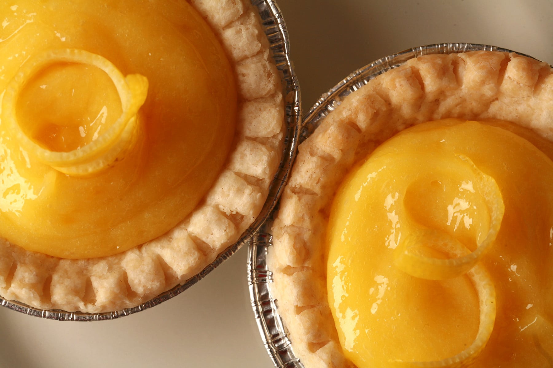 A close up view of two lemon tarts.