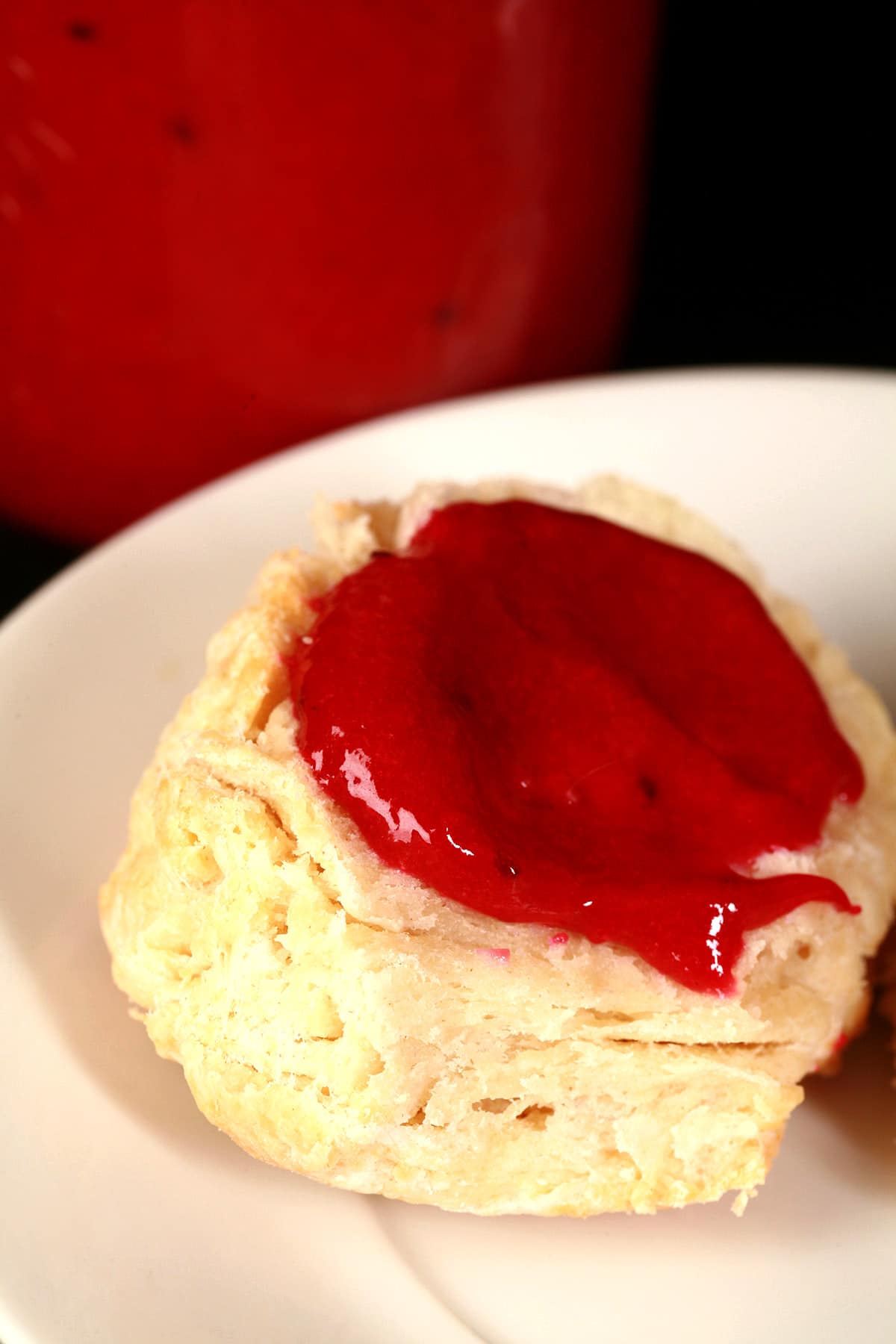 A close up photo of a biscuit topped with blackcurrant curd.