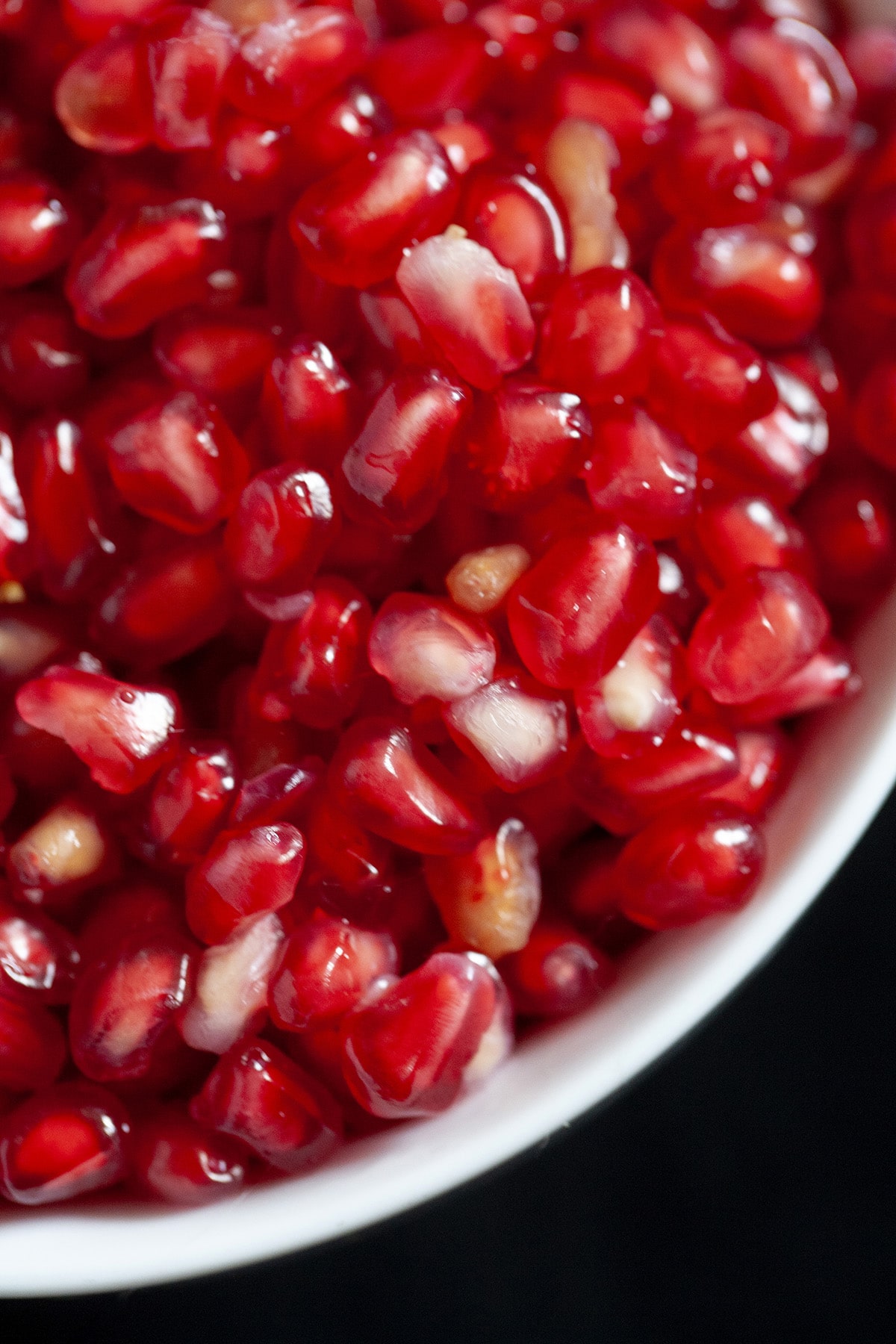 A close up view of a bowl of pomegranate arils.
