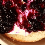 A bagel spread with cream cheese and topped with this small batch blueberry jam.