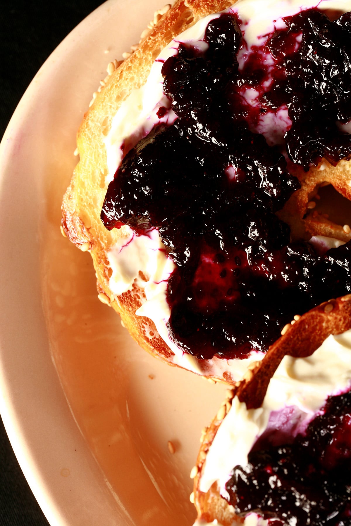 A bagel spread with cream cheese and topped with this small batch blueberry jam.