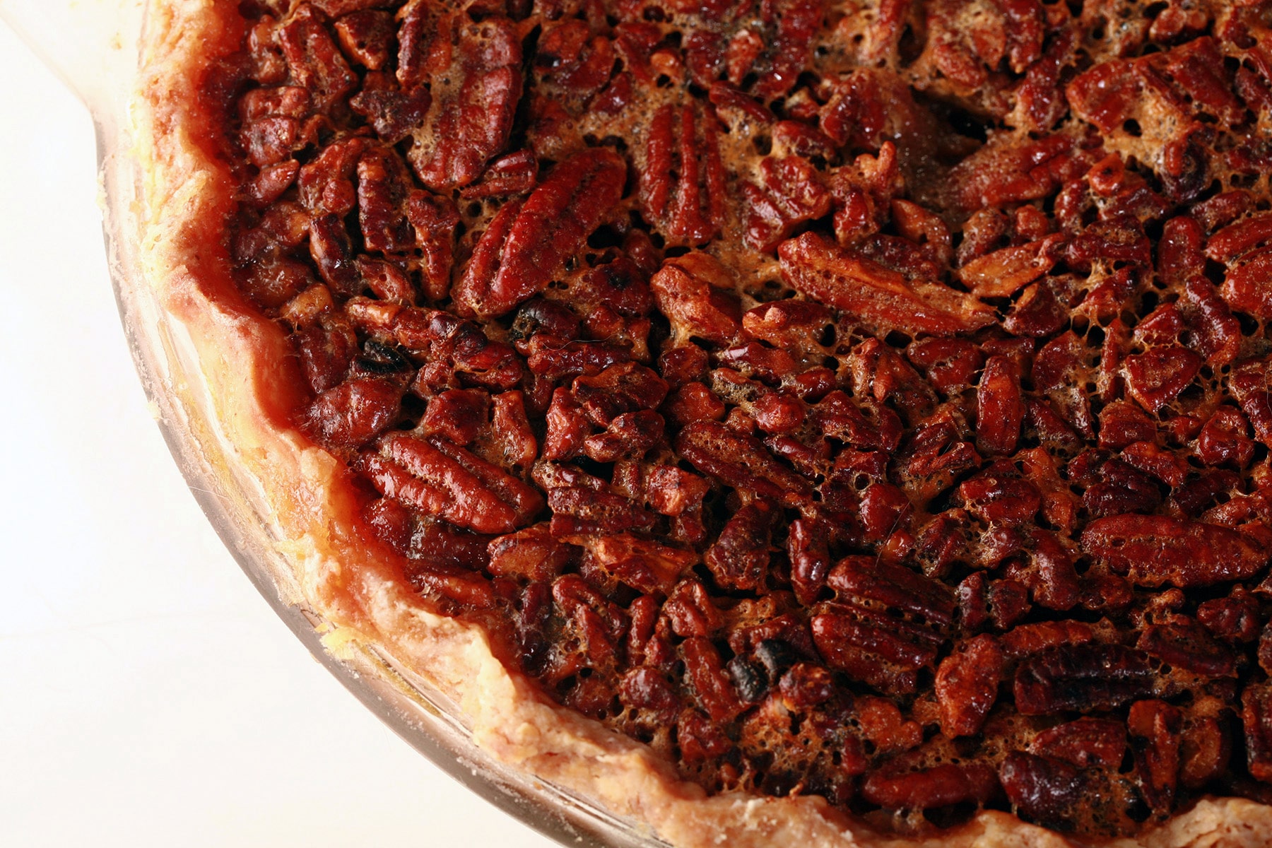 A close up view of a whole, uncut Southern Comfort Pecan Pie.