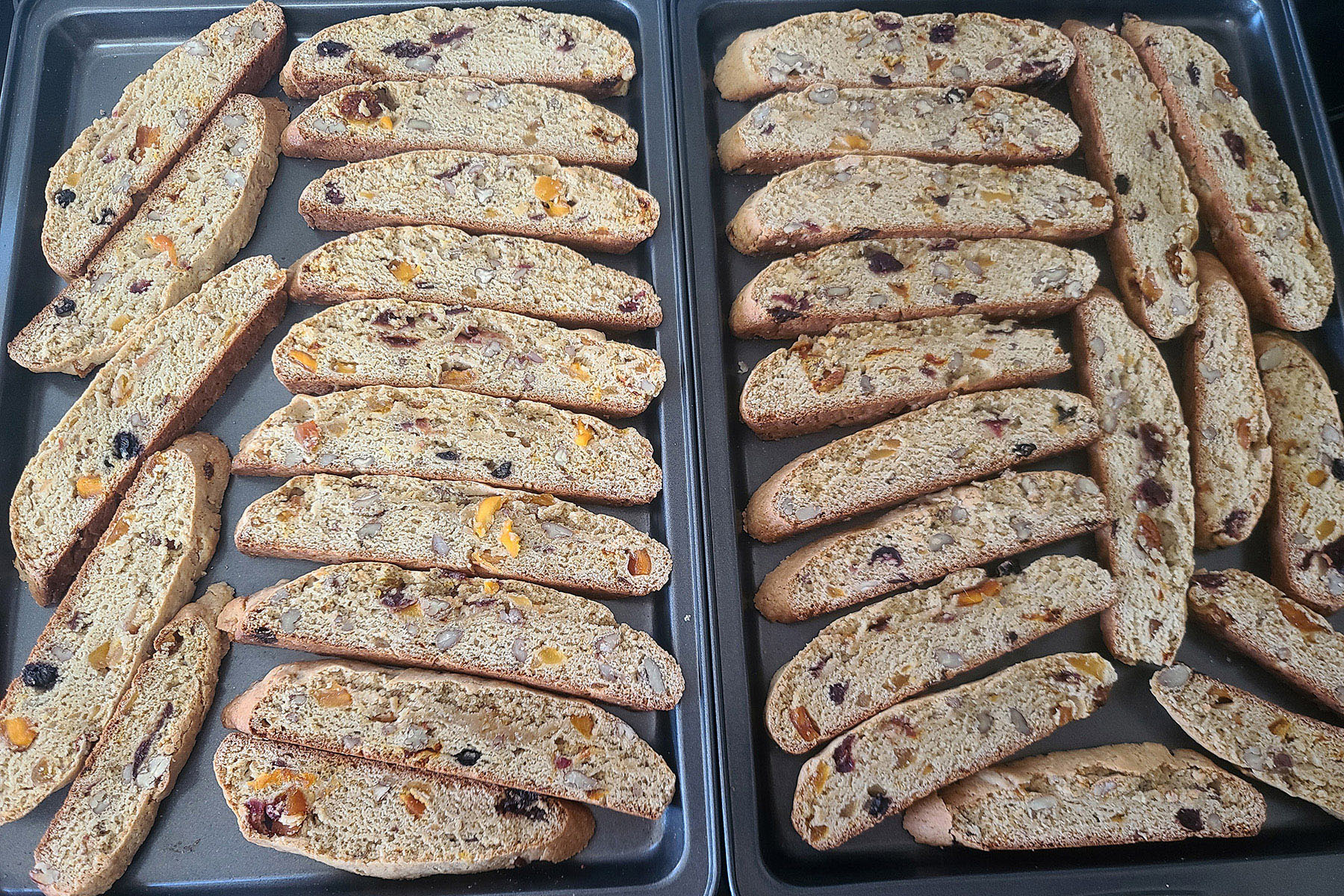 A close up view of two pans with the sliced biscotti arranged on them.