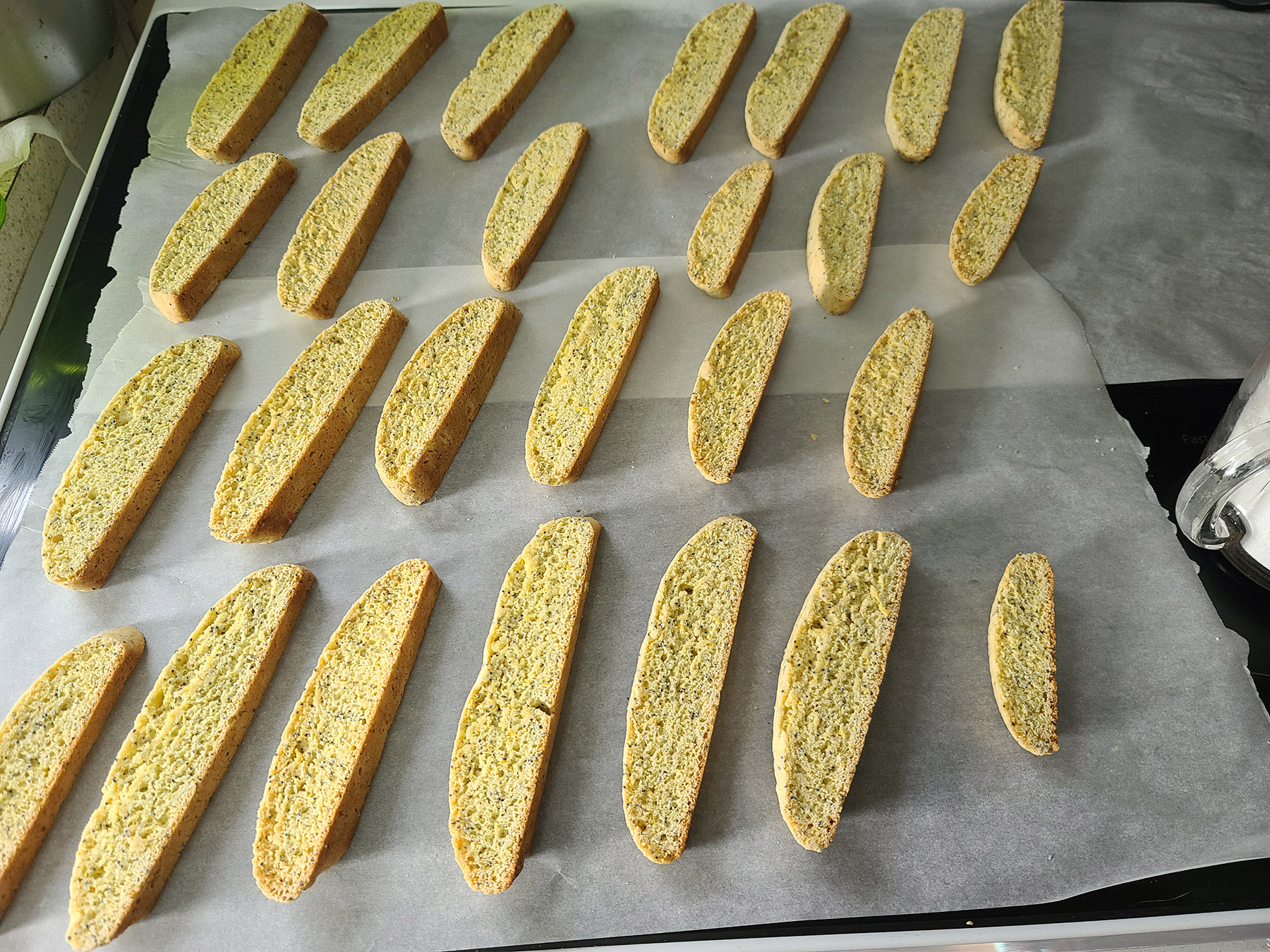 The baked biscotti laid out on a parchment lined work surface.