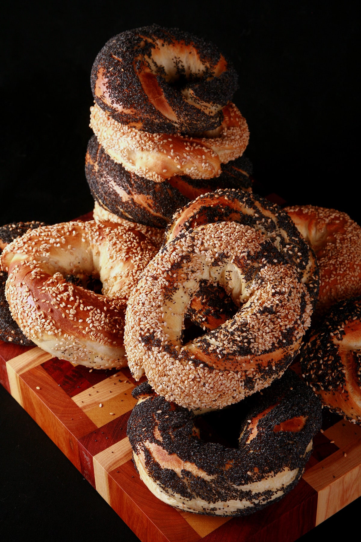 An assortment of Montreal Bagels piled on a cutting board.