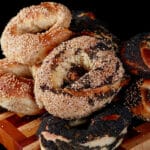 An assortment of Montreal Bagels piled on a cutting board.