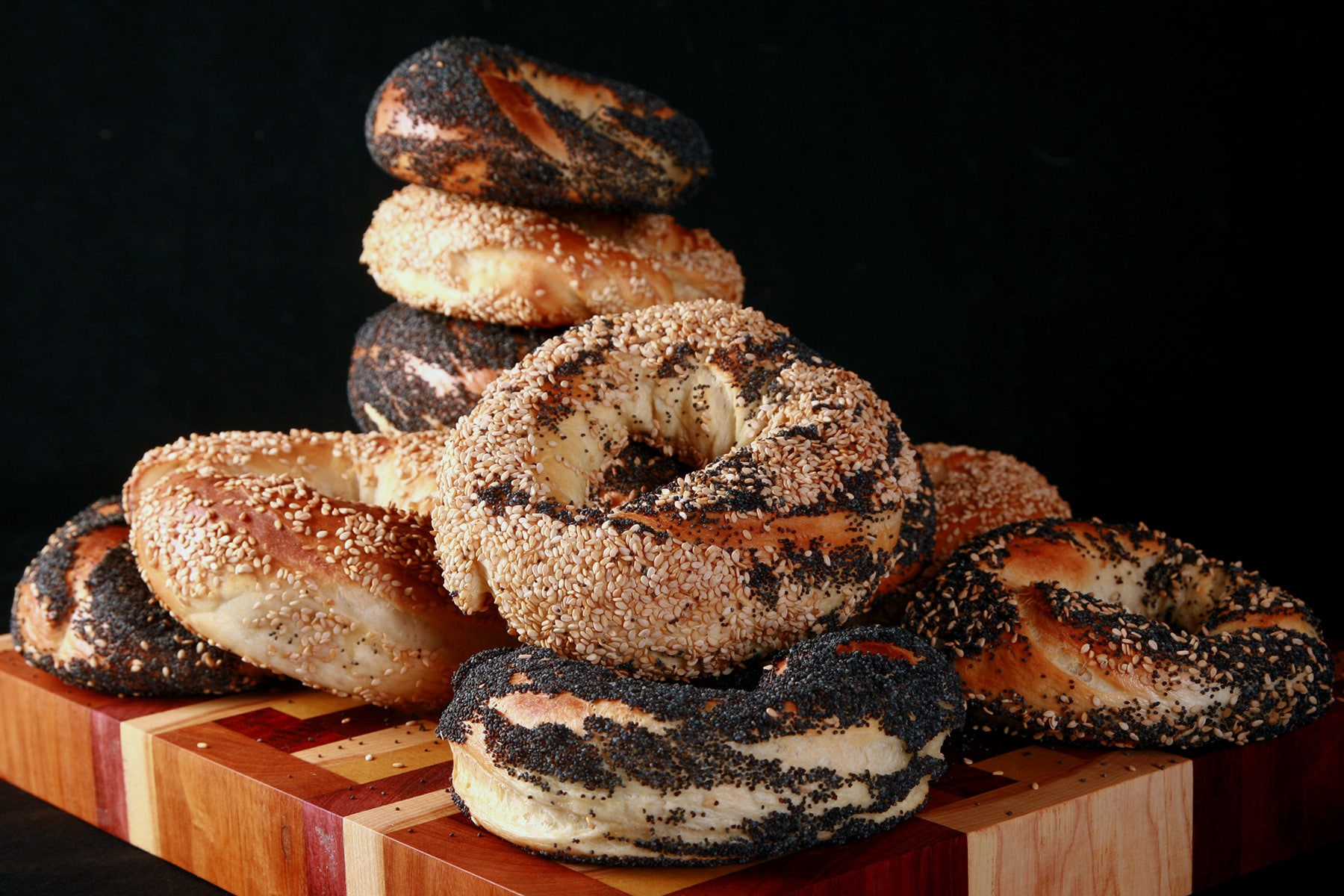 An assortment of Montreal Style Bagels piled on a cutting board.