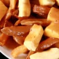 A bowl of Poutine, made with fries, gravy, and white cheese curds.