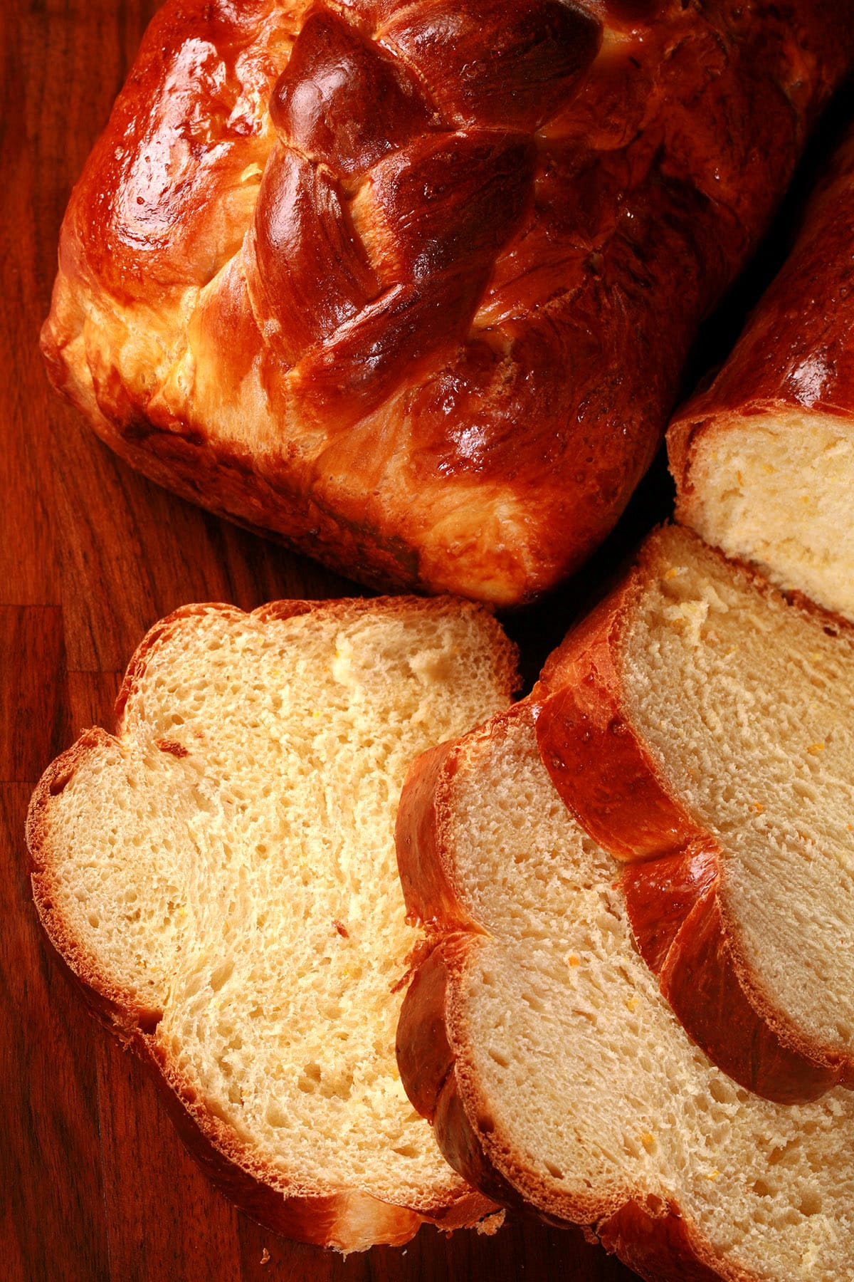 A sliced loaf of Ukrainian Easter bread, in front of another whole loaf of it.