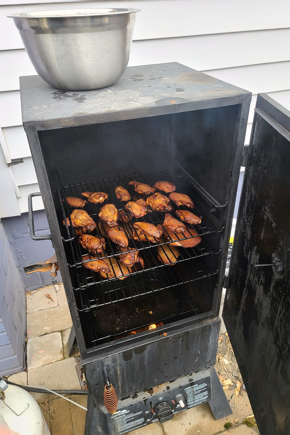 A rack of chicken wings in a smoker.