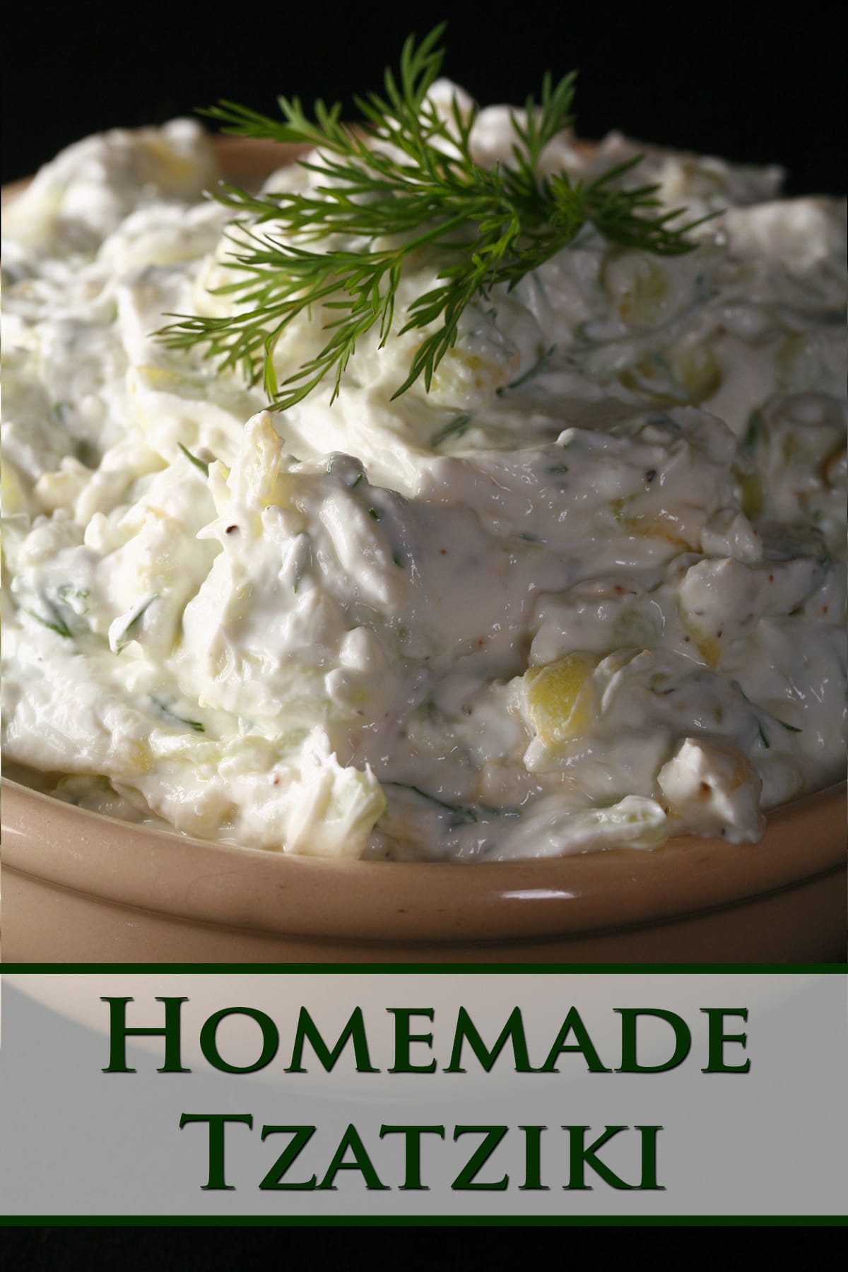 A bowl of thick tzatziki dip, garnished with fresh dill.