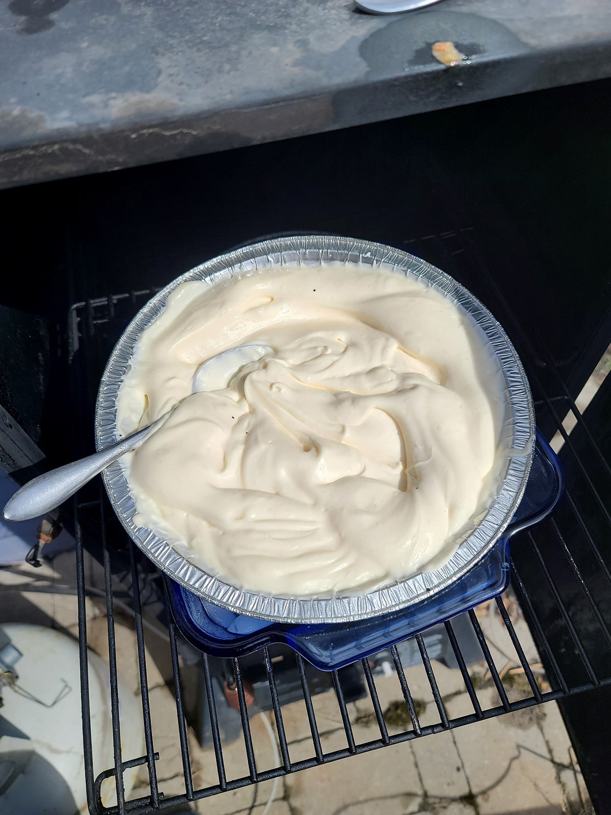 A pan of mayonnaise in a smoker.