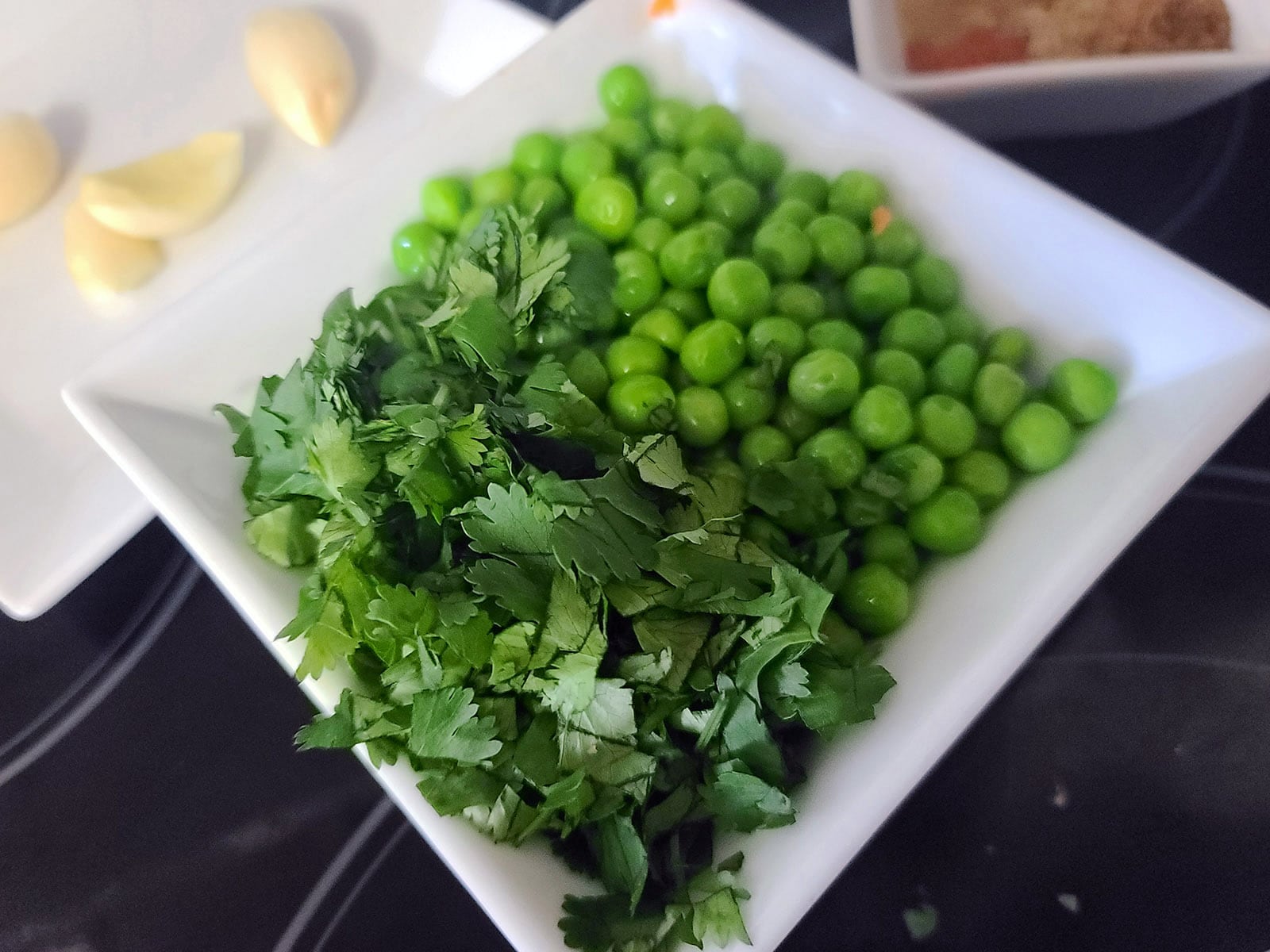 A bowl of peas and chopped cilantro.