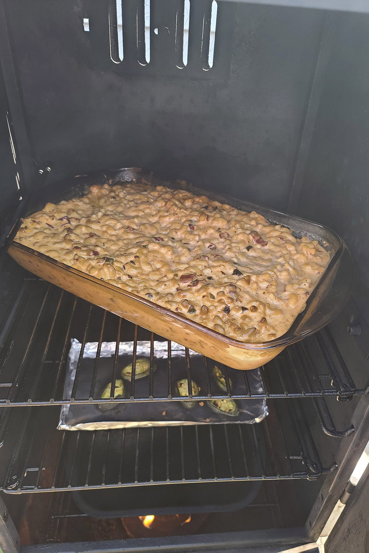 The pan of mac and cheese in the smoker.