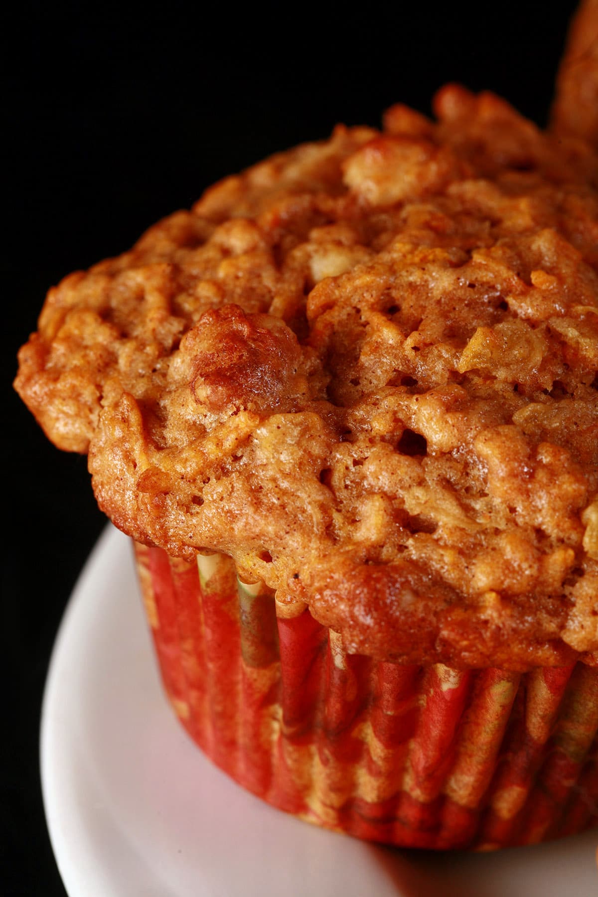 A close up view of a carrot cake muffin on a white plate.
