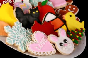 A plate of brightly colored cookies done up in a variety of themes - Halloween, Christmas, Easter, Valentine's Day, etc.