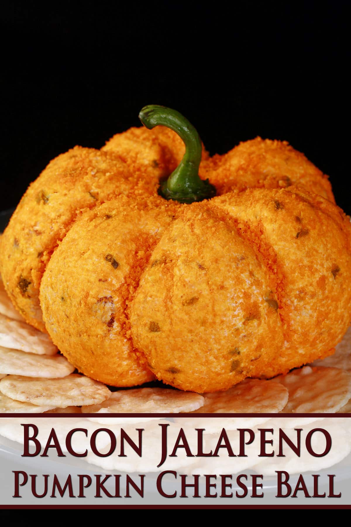 A bacon jalapeno pumpkin shaped Halloween cheese ball on a plate of crackers.